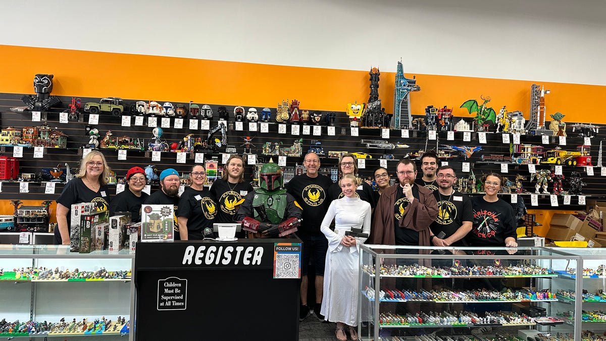 The Arizona Brick Co. team behind the register, in front of a wall of built LEGO® sets, with staff in Star Wars costume