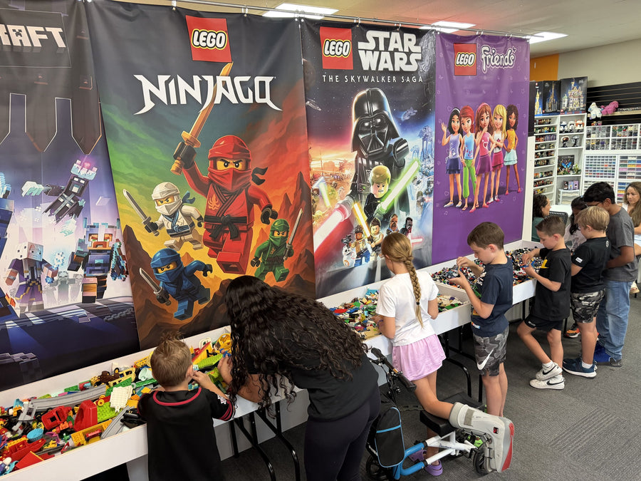 Party guests picking pieces from the long build wall under LEGO Ninjago and Star Wars banners