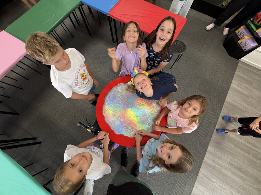 Overhead view of the spinner battle table with children competing around it
