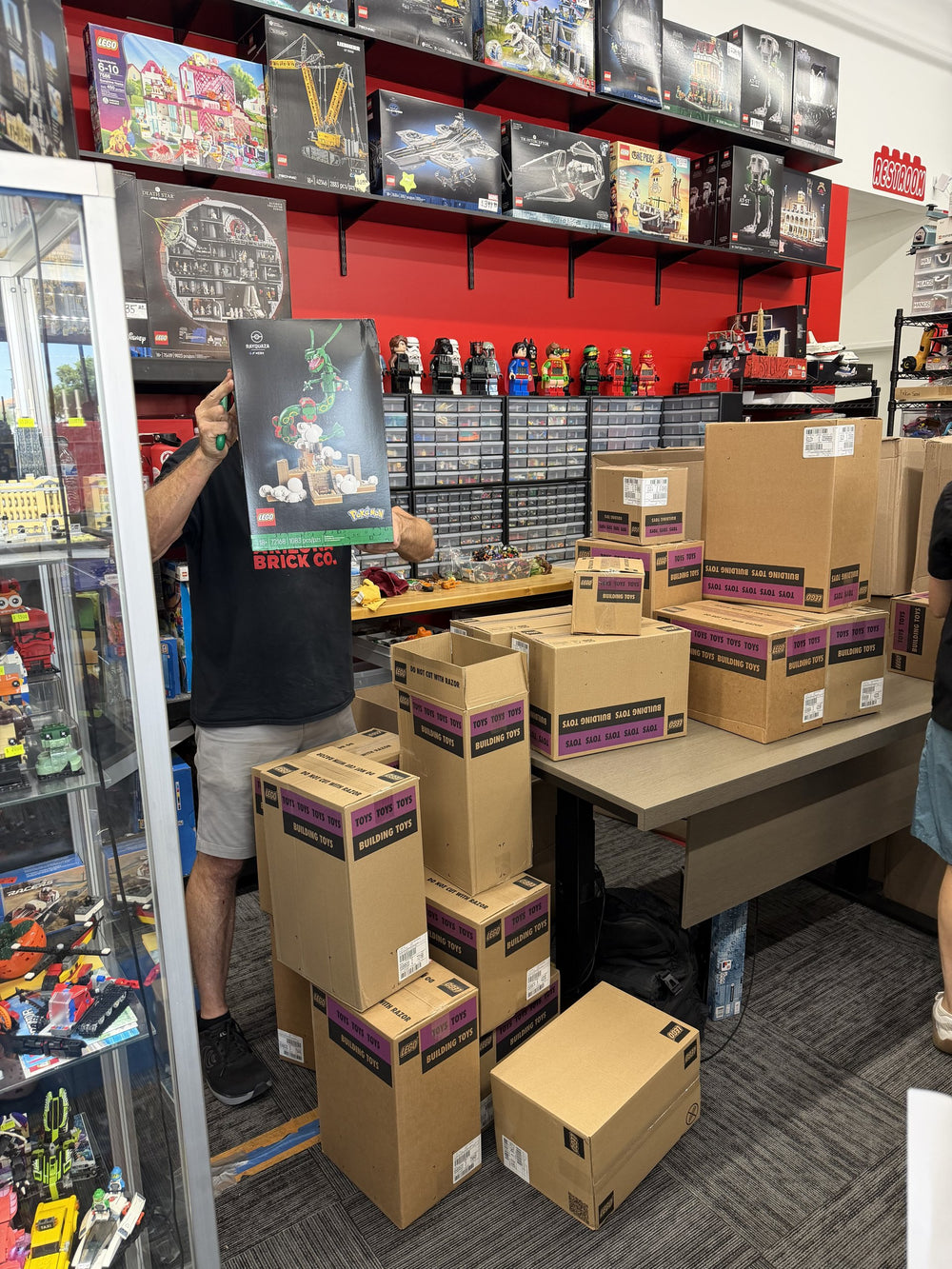 Boxes of a purchased LEGO collection stacked on tables at Arizona Brick Co.
