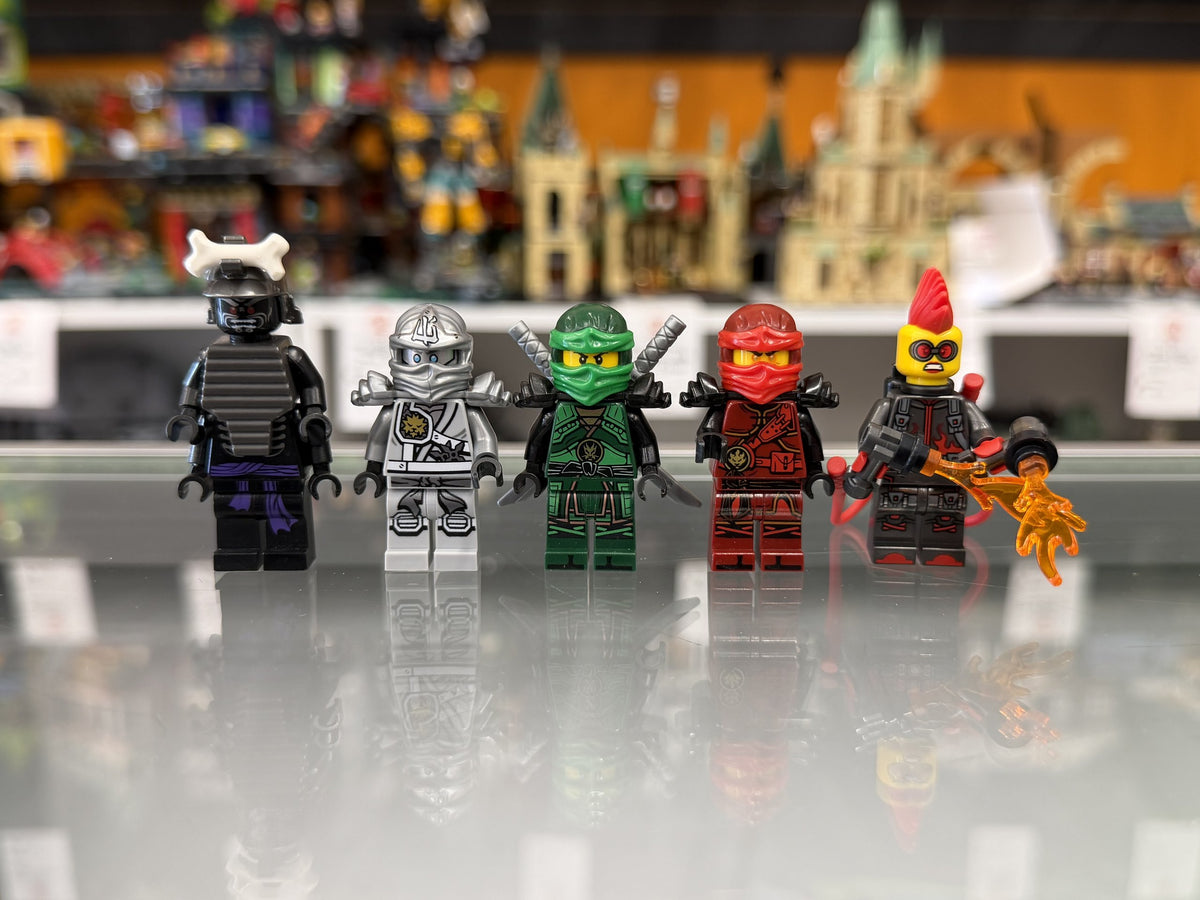 A row of Ninjago LEGO minifigures on the glass counter at Arizona Brick Co.